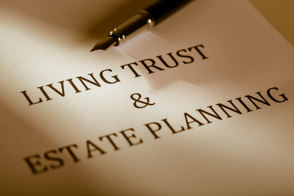 pen lying on a piece of paper that states living trust and estate planning