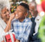 Playful Senior Woman Pinches Her Adorable Grandson's Cheeks At Christmastime.